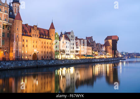 Waterfront Mietskasernen und Kran spiegelt sich auf der Mottlau in der Abenddämmerung. Danzig, Polen Stockfoto