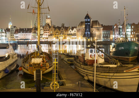 Boote, mittelalterliche Kran und Waterfront Mietskasernen spiegelt sich auf der Mottlau durch Nacht verankert. Danzig, Polen Stockfoto