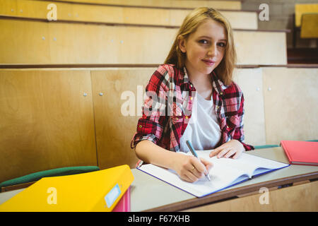 Lächelnde Student Notizen während des Unterrichts Stockfoto