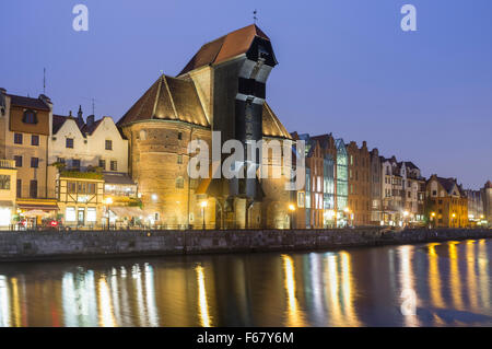 Mittelalterliche Kran und Waterfront Mietskasernen spiegelt sich in der Abenddämmerung am Mottlau. Danzig, Polen Stockfoto