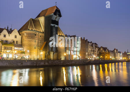 Mittelalterliche Kran und Waterfront Mietskasernen spiegelt sich in der Abenddämmerung am Mottlau. Danzig, Polen Stockfoto