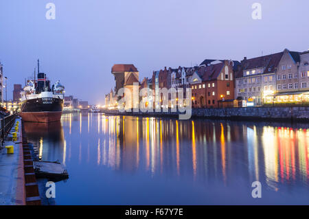 Waterfront Mietskasernen mittelalterliche Kran und SS Sołdek Museumsschiff spiegelt sich auf der Mottlau in der Abenddämmerung. Danzig, Polen. Die SS Soldek Stockfoto