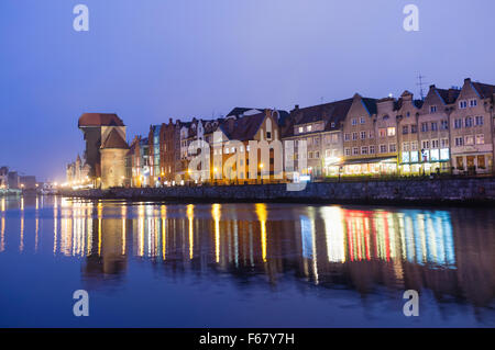 Waterfront Mietskasernen und Kran spiegelt sich auf der Mottlau in der Abenddämmerung. Danzig, Polen Stockfoto