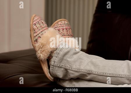 Eine Frau mit ihren Füßen tragen Hausschuhe England UK entspannend Stockfoto