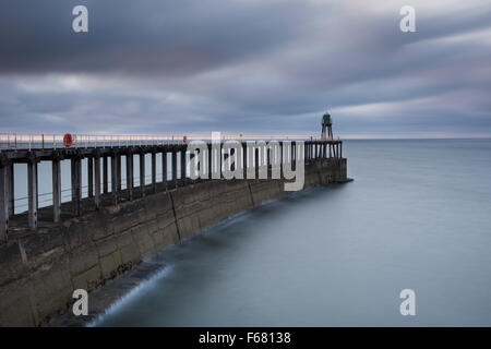 Langzeitbelichtung Schuss Whitbys Pier West, in der Dämmerung - die Blautöne des Meeres und des Himmels schaffen eine ruhige, beschauliche malerische Szene. Yorkshireküste, GB, UK. Stockfoto