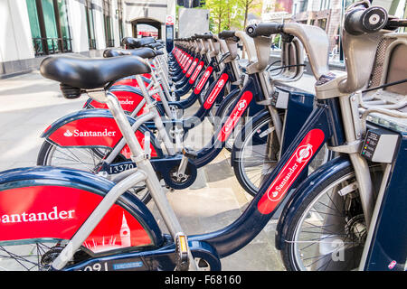 Boris Bikes mit dem roten Santander-Sponsoring-Logo, geparkt in einem Stand in der City of London, England Stockfoto