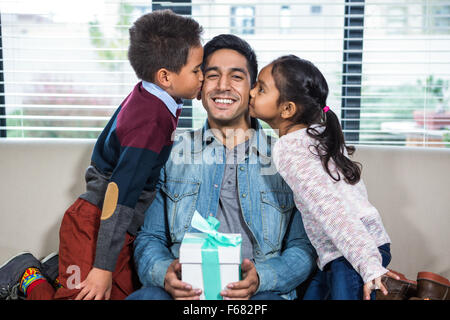 Glücklicher Vater von seinen Kindern ein Geschenk erhalten Stockfoto