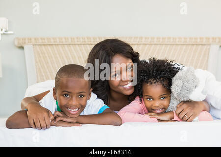 Mutter und Kinder auf Bett liegend Stockfoto