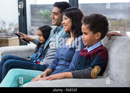 Glückliche junge Familie vor dem Fernseher Stockfoto