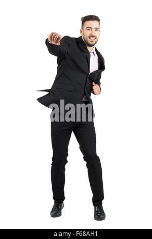 Fröhliche junge bärtige Geschäftsmann springen begeistert mit geballten Fäusten. Ganzkörper-Länge-Porträt über weißen isoliert Stockfoto