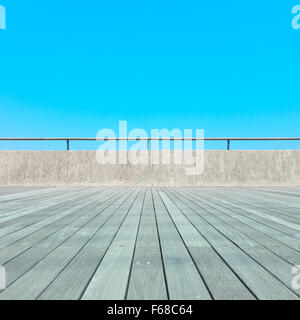 Balkon, hölzernen Dielenboden, Betonzaun und blauer Himmel. Outdoor-Architektur, unten Perspektive Stockfoto