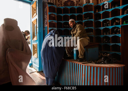 Frau in Burka lässt ihre Schuhe am Eingang zum Heiligtum von Ali in Mazar-i Sharif, Afghanistan Stockfoto