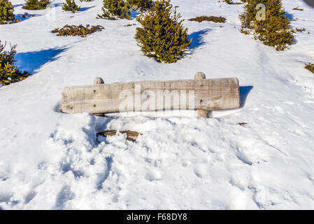 weiße Holzbank im Schnee begraben Stockfoto