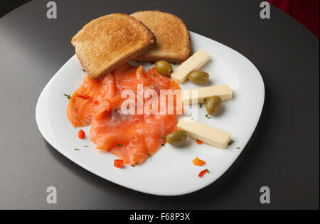 Geräucherter Lachs Filets mit geröstetem Brot und Oliven auf weißen Teller Stockfoto