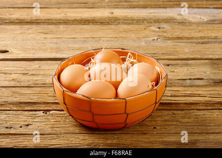 Braune Frischeier in Terrakotta Schale auf Holztisch Stockfoto