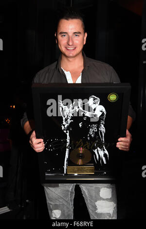 München, Deutschland. 13. November 2015. Österreichische Sänger Andreas Gabalier posiert mit einer goldenen Schallplatte für sein Lied "Amoi Seng Ma Uns Wieder", auf der Aftershow-Party zu seinem Konzert in München, 13. November 2015. Foto: FELIX HOERHAGER/DPA/Alamy Live-Nachrichten Stockfoto