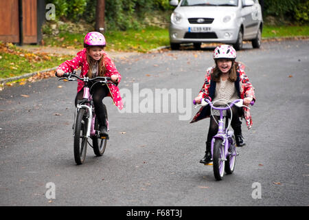 Horizontale Porträt der jungen Mädchen, die ihre Rennräder entlang der Straße. Stockfoto