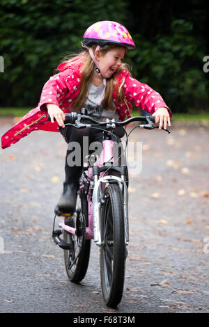 Vertikale Porträt eines jungen Mädchens mit ihrem Fahrrad auf der Straße. Stockfoto