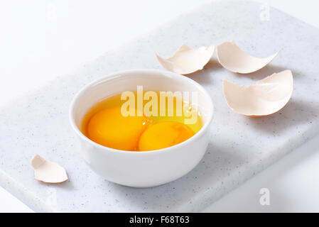 Frisches Eiweiß und Eigelb in die Schüssel weiß Stockfoto