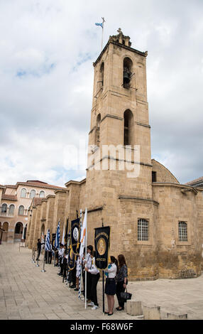 Schüler mit ihrer Schule Fahnen und Symbole stehen außerhalb der Kirche von Agios Ioannis in Nikosia Stockfoto