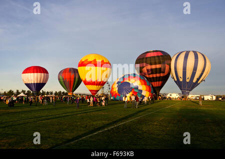 6 angebunden Ballons immer bereit, aufsteigen, große Menschenmenge unten auf Feld. Stockfoto