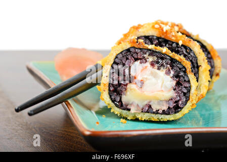 Gebackenes Sushi-Rollen auf Türkis Teller serviert Stockfoto