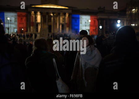 Tausende von Menschen versammeln sich am Trafalgar Square in London, UK in Solidarität mit dem französischen Volk nach den Anschlägen in Paris, wo mindestens 130 Menschen, durch eine Reihe von Terroranschlägen getötet wurden. Der Brunnen am Trafalgar Square sind mit der französischen Tricolore beleuchtet. Die Menge Kerzen angezündet und sang die Marseillaise, die französische nationale Hymne Stockfoto