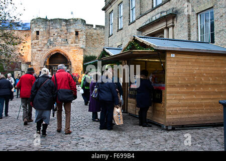 Lincoln, England, Chriskindlemarkt, Verkaufsstände und Scharen von fair Besucher vor den Toren und Türmen der Lincoln Castle. Stockfoto