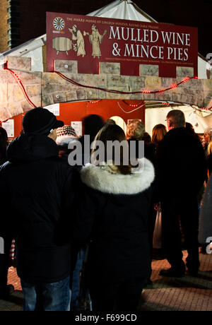 Lincoln, England, Chriskindlemarkt, Messe Besucher an einem Stand verkaufen Glühwein und Mince Pies aufgereiht. Stockfoto