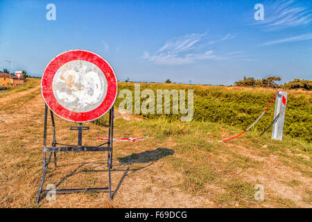 Verkehrszeichen und Landstraßen - zum verblichene Höchstgeschwindigkeit 30 km/h Zeichen ein Zeichen, das Verbot des Zugangs zu den Trail am Ufer eines Flusses Stockfoto