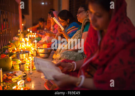 DHAKA, Bangladesch-14. November: Anhänger besuchen Gebet mit brennendem Weihrauch und leichte Öl-Lampen vor Pause Fasten während eines religiösen Festes Rakher Upabash in Dhaka am 14. November 2015 genannt. Bengali Leute des hinduistischen Glaubens in Bangladesch sitzen im Gebet feiern im 18. Jahrhundert hinduistischen Heiligen Baba Lokenath mit "Rakher Upobas" Gebet und Fastentag jedes Jahr Tausende von hinduistischen Anhänger versammeln sich vor Shri Shri Lokenath Ramakrishna Ashram Tempel für das Kartik Brati oder Rakher Upobash religiöse fest in Barodi, in der Nähe von Dhaka, Bangladesh. Gläubigen sitzen vor Kerzen Licht (name Stockfoto