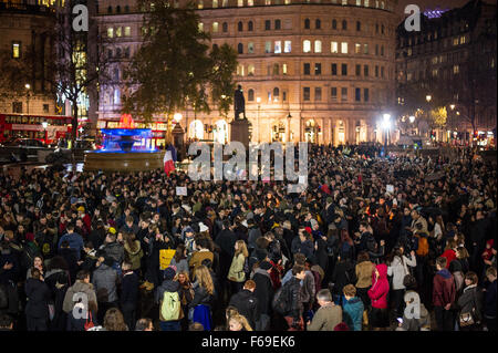 London, UK. 14. November 2015. Tausende versammeln sich am Trafalgar Square für ein Candle-Light-Mahnwache in Solidarität mit den Opfern von gestern Abend Terroristen Anschläge in Paris. Die National Portrait Gallery ist mit den Farben der französischen Tricolore Flagge beleuchtet. Stockfoto