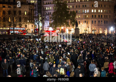 London, UK. 14. November 2015. Tausende versammeln sich am Trafalgar Square für ein Candle-Light-Mahnwache in Solidarität mit den Opfern von gestern Abend Terroristen Anschläge in Paris. Die National Portrait Gallery ist mit den Farben der französischen Tricolore Flagge beleuchtet. Stockfoto