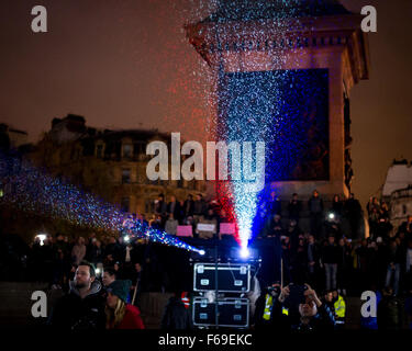 London, UK. 14. November 2015. Tausende versammeln sich am Trafalgar Square für ein Candle-Light-Mahnwache in Solidarität mit den Opfern von gestern Abend Terroristen Anschläge in Paris. Die National Portrait Gallery ist mit den Farben der französischen Tricolore Flagge beleuchtet. Stockfoto