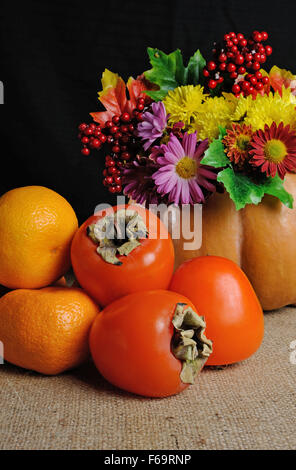 Obst auf dem Tisch mit Blumen in einer Vase-Kürbis Stockfoto