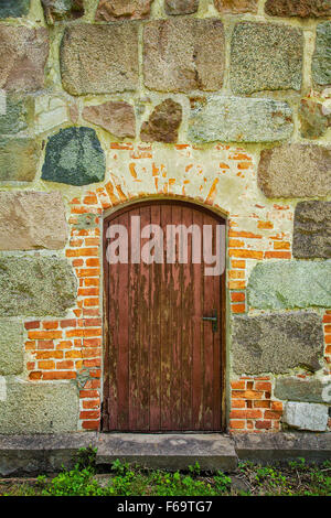 Bild einer alten Tür in einem Stein ummauerten Gebäude. Stockfoto