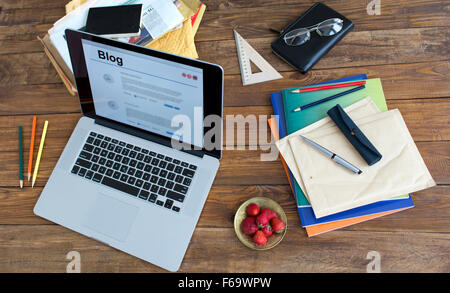 Sehr natürlich aussehende Draufsicht der Arbeiten Schreibtisch mit Laptop Computer Erdbeer bunten Broschüren Stift Bleistift Brille Umschlag vintage Stockfoto