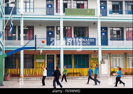 Kinder spielen Basketball auf dem Schulhof von einem Gymnasium in der Stadt Volos, Thessalien, Griechenland Stockfoto