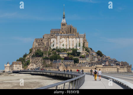 Touristen auf der Brücke bei der Mont Saint-Michel-Insel-Gemeinde an der Mündung des Flusses Cousenon, in der Nähe von Avranches, Normandie Frankreich. Stockfoto