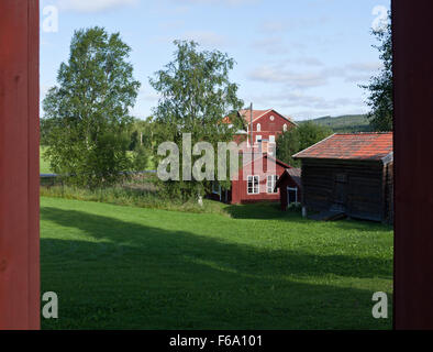 HALSINGLAND, SCHWEDEN AM 24. JULI 2015. Blick auf einen schönen hölzernen Gehöft. Falu rot Lackfarben und Ackerland. Redaktionelle Nutzung. Stockfoto