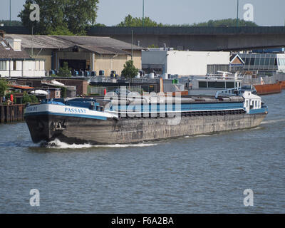 Passant ist ein Containerschiff im Amsterdam-Rijn kanaal, das eine Reihe von Schüttgütern wie Kohle, Getreide und Öl transportiert. Das Schiff ist Teil der Logistikkette und erleichtert den Warenverkehr über den Wassertransport zur Unterstützung des Welthandels. Seine Vielseitigkeit sowohl als Massengutfrachter als auch als Öltanker macht ihn zu einem wichtigen Bestandteil der Schifffahrtsindustrie. Stockfoto