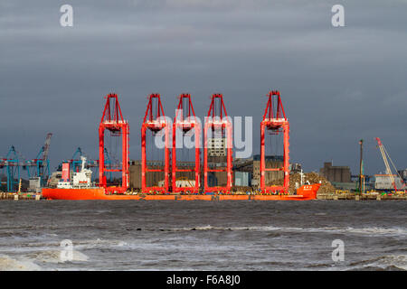 Operational Cantilever Rail-Mounted Gantry (CRMG) Cranes; New Brighton, Liverpool Docks, Großbritannien, November 2015. Wetter in Großbritannien. Starke nächtliche Winde haben den Nordwesten Englands mit Wetterwarnungen in Kraft für ganz Merseyside geschlagen. Chinesischer Lastträger Zen Hua 23 der Transport von Portalkranen und anderen Schifffahrten im Fluss Mersey musste turbulente Meere und Sturmwinde in der Mündung, die den Eingang zur Irischen See bildete, ertragen. Stockfoto