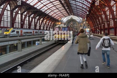 Mehrere Jugendliche zornbebend zu einen Zug, dessen Abreise bevorsteht. Oberirdischen Bahnhof Antwerpen-Plattform. Stockfoto