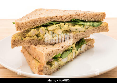 Ein Coronation Chicken Sandwich auf einem Teller mit weißem Hintergrund Stockfoto