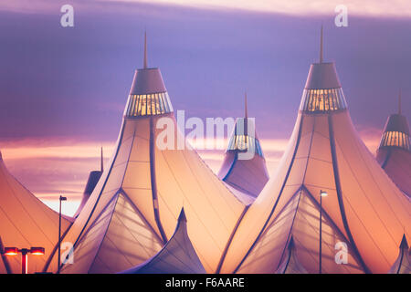 Glühende Zelte von DIA bei Sonnenaufgang. Denver International Airport bekannt für Spitzen Dach. Gestaltung von Dach reflektiert Schnee-capp Stockfoto