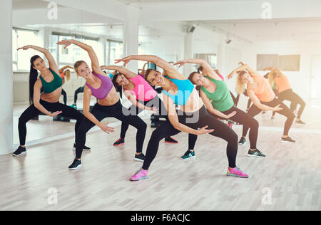 Aerobic-Kurs in einem Fitnessstudio mit einer Gruppe von attraktiven junge Frauen in bunten Sportbekleidung Training im Synchronisierung in einem w passen Stockfoto
