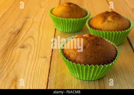 Muffins im Grünbuch Cupcake Halter auf einem hölzernen Hintergrund horizontale, selektiven Fokus Stockfoto