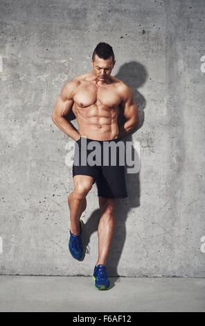 Fitness model stehen vor grauem Hintergrund, kein Hemd zeigt Bauchmuskeln, Nahaufnahme, Fitness Konzept Werbung Stockfoto