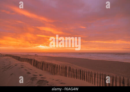 Fußspuren im Sand & Pastell Sonnenuntergang über der Nordsee in Katwijk Aan Zee, Südholland, Niederlande. Stockfoto