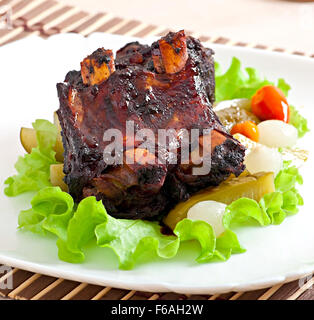 Gebackenes Rindfleisch Rippen in Honig-Soja-Marinade mit eingelegtem Gemüse Stockfoto